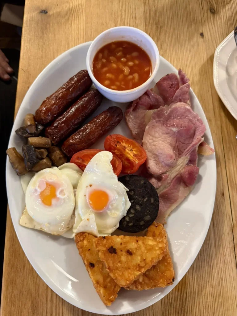 A delicious looking all-day breakfast served with sausages, bacons, eggs and hash browns